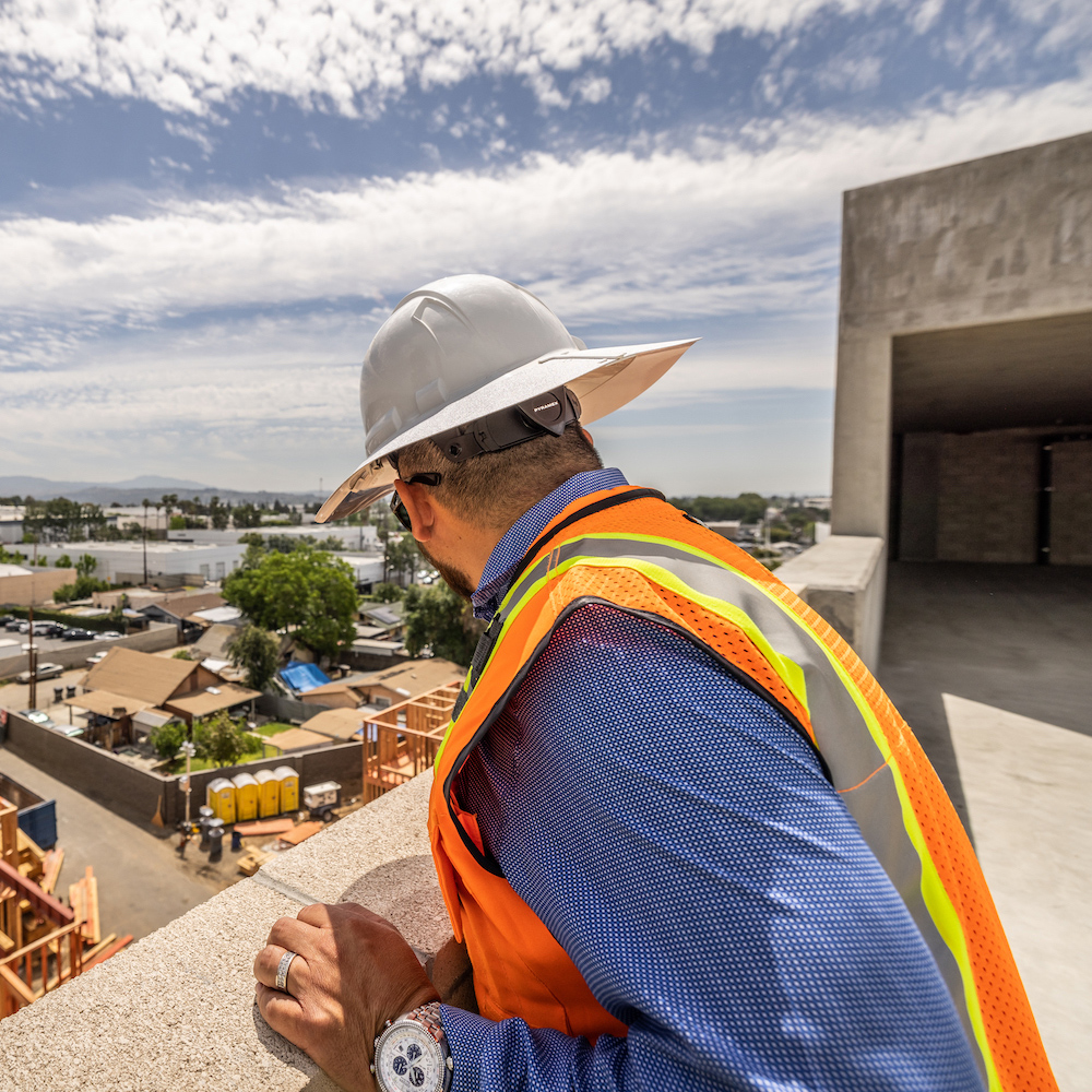 JPI associate peering over railing